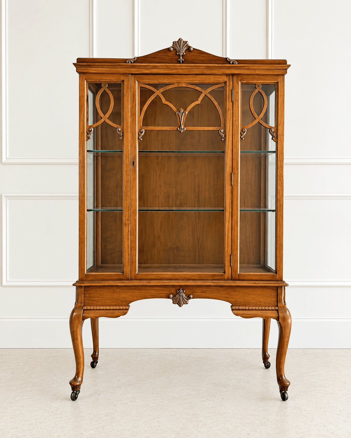 A classic Sheesham Display Cabinet with glass doors, intricate wooden arches, and elegant cabriole legs, set against a white paneled wall.