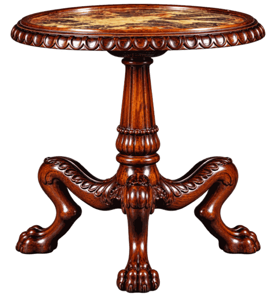 An ornate antique wooden pedestal table with a round marble top and three carved legs featuring detailed lion paw feet against a black background.